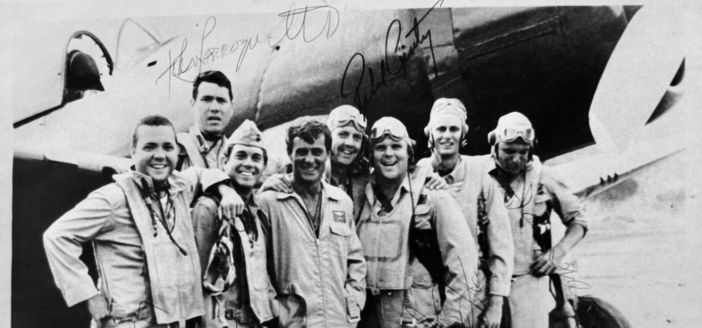 Photo souvenir en noir et blanc d’un équipage de pilotes devant leur avion