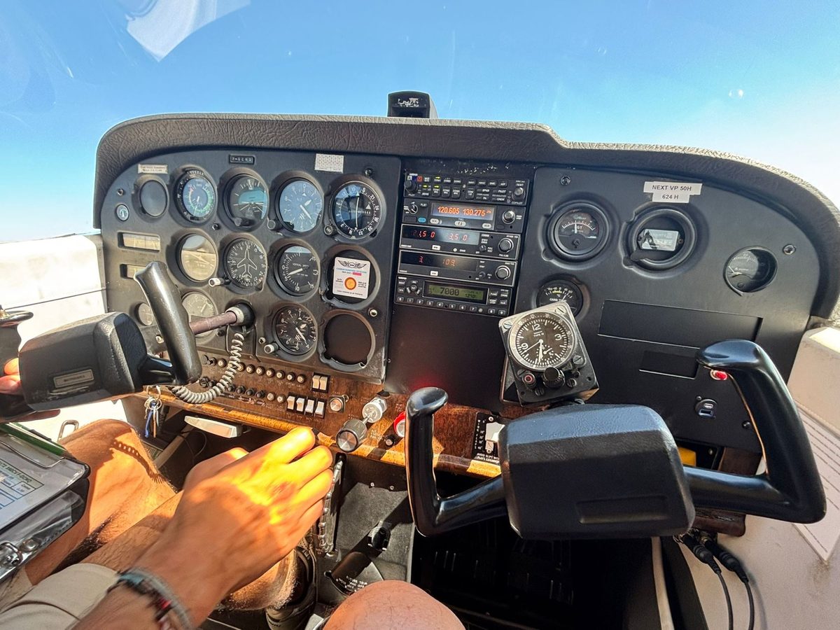Le tableau de bord d’un Cessna 172 du club en vol, vu depuis le siège avant, sous un ciel bleu