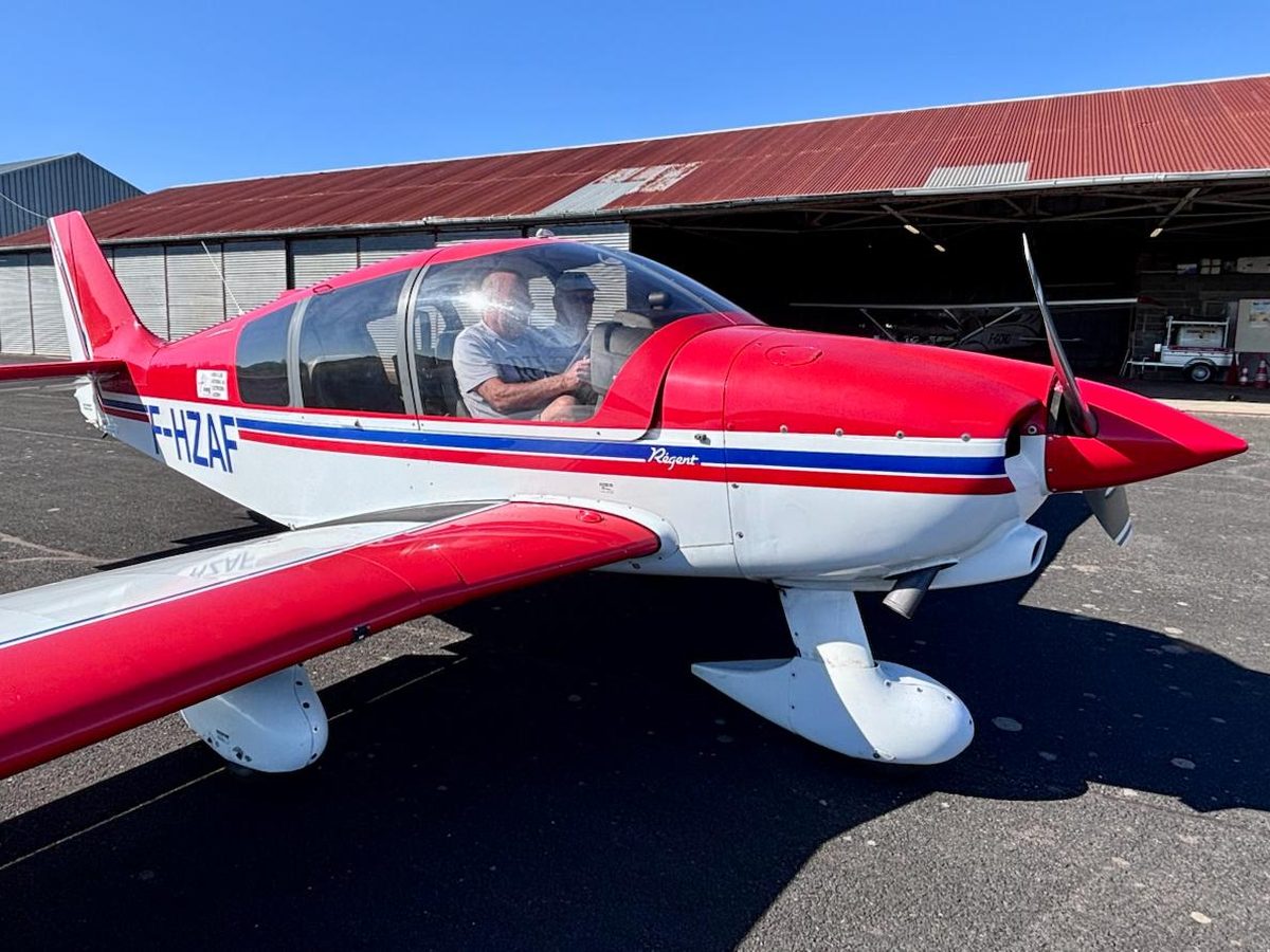 Un élève aux commandes du Robin DR400 F-HZAF du club, avec son instructeur, devant le hangar